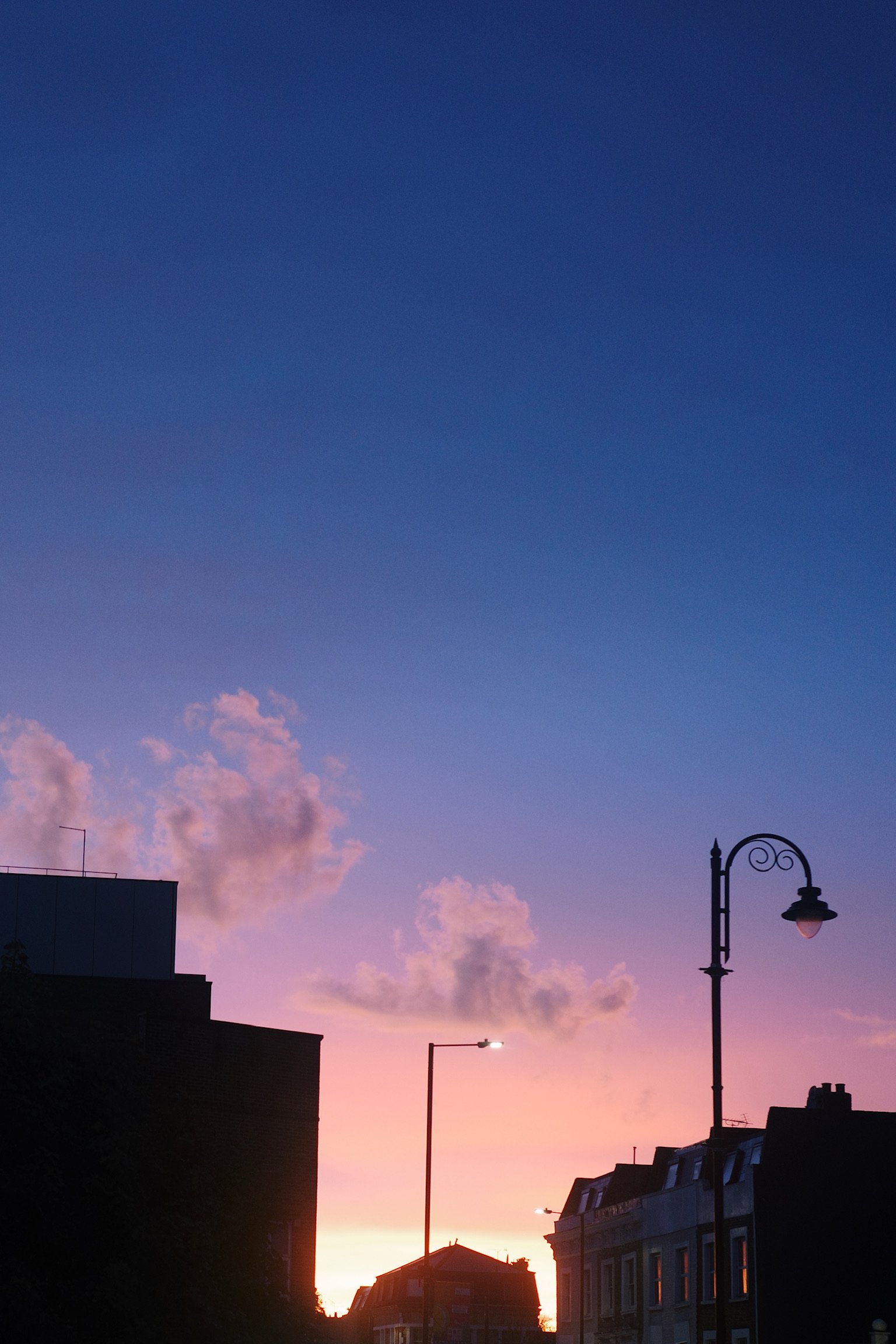 sunset in london, pink to purple gradient, street lamps in a distance.