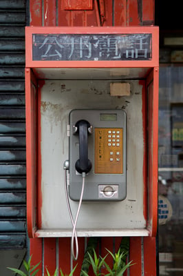 An old school roadside pay phone in good conditions with legible buttons and instructions.