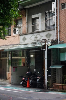 old buildings in taipei with stone façade and walkways occupied by scooters.