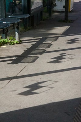 shadows of benches and window decorations at a tram station