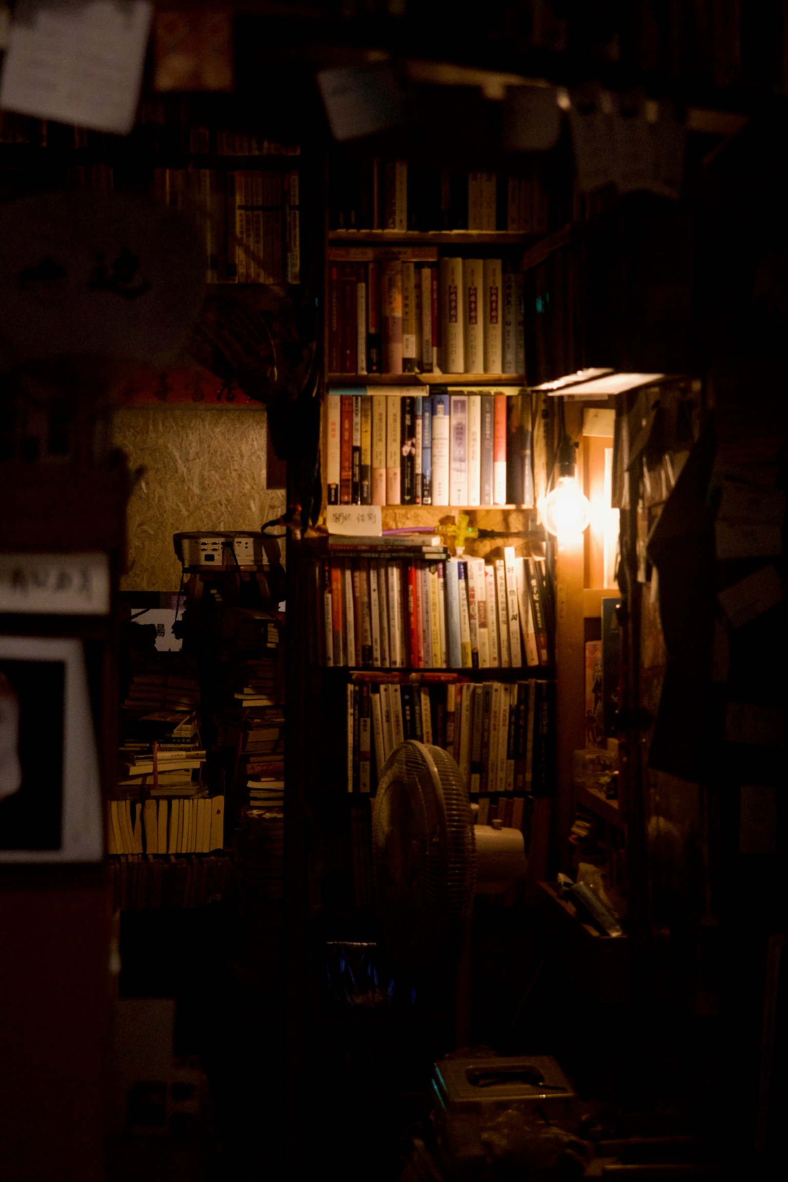 A dimly lit bookstore with makeshift shelves.