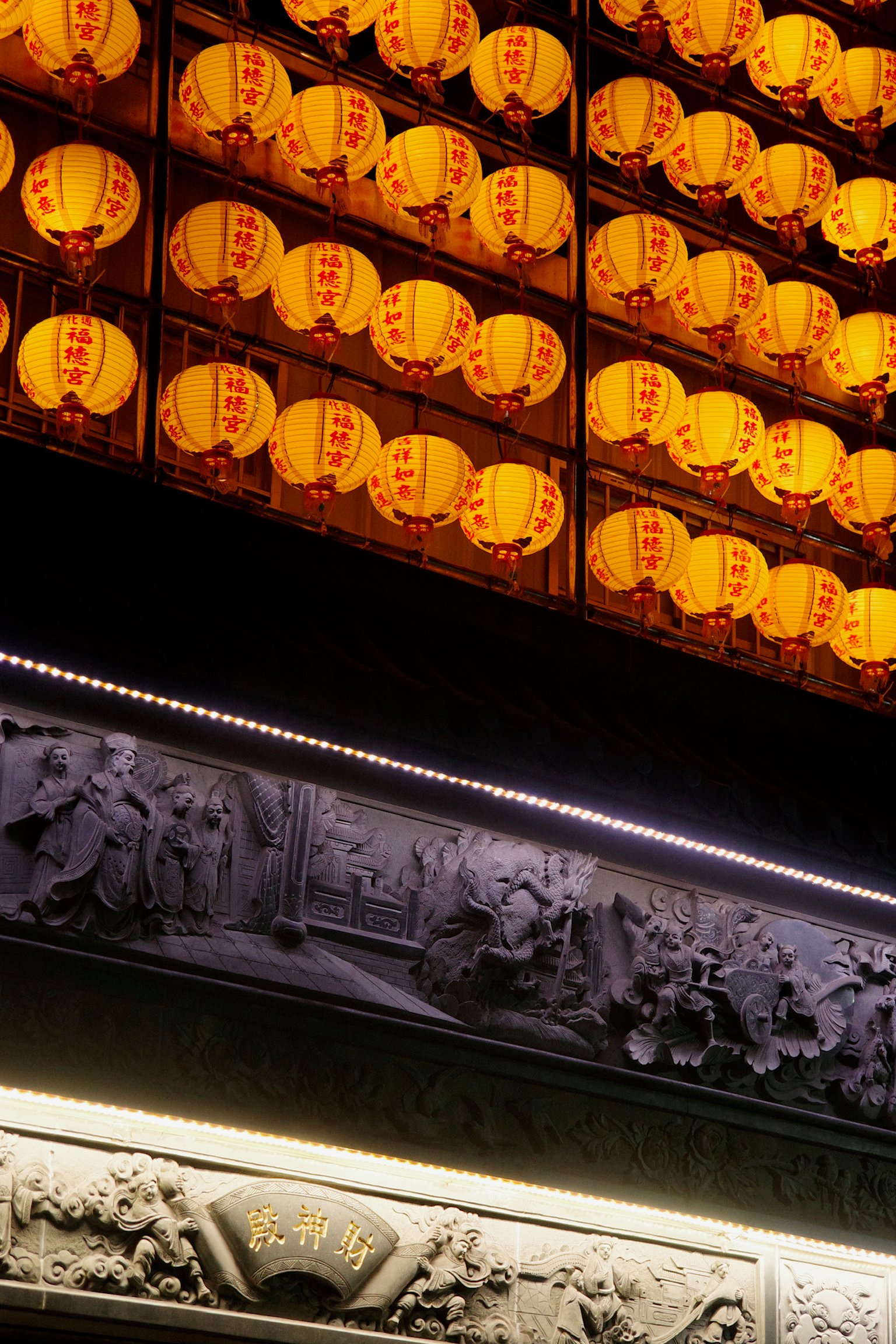 Rows and rows of lanterns lit and marked with “TongHua Fu De Temple”, and the structure below says “Temple of the money of God”