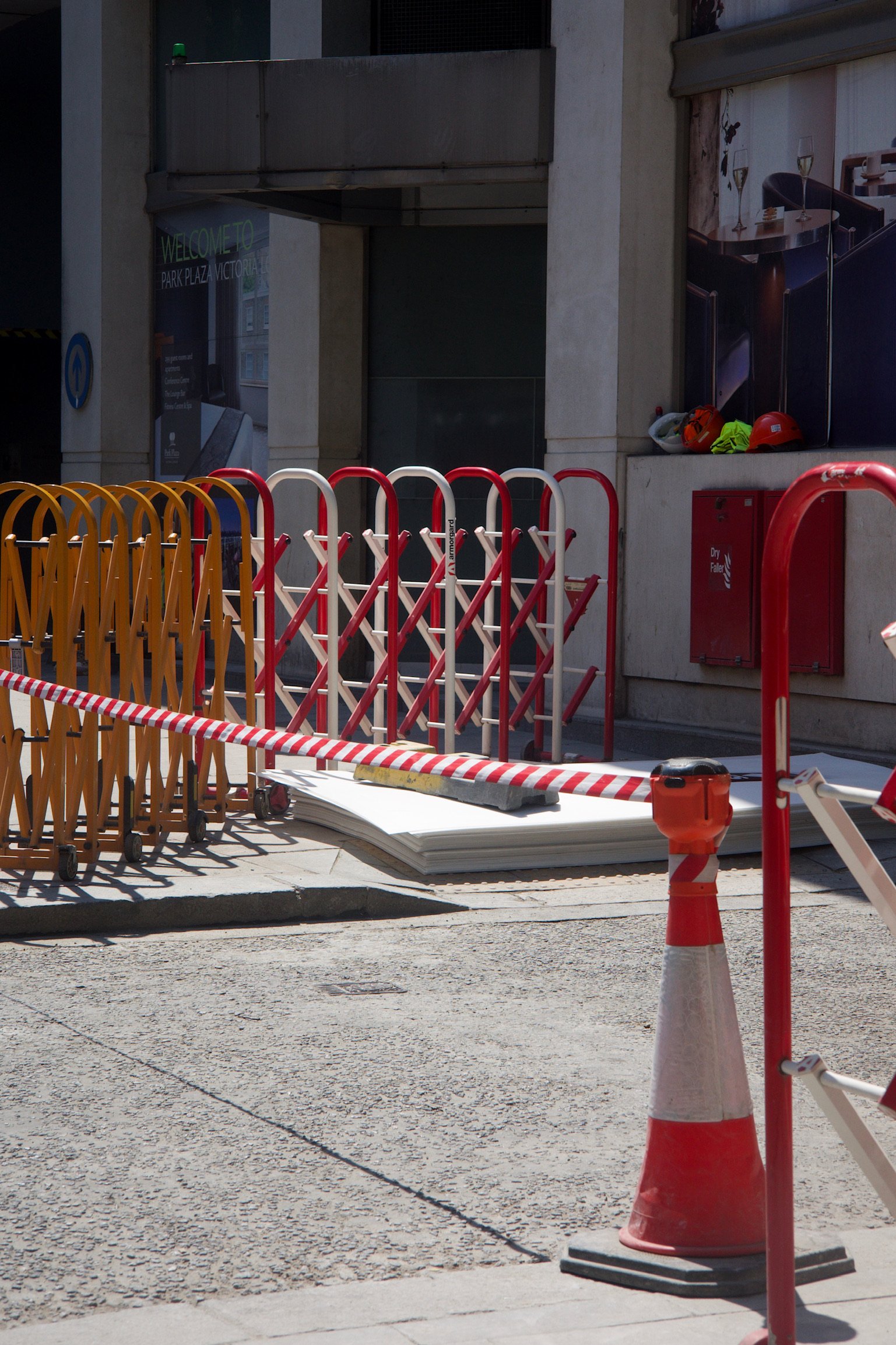 construction site with yellow and red fences and traffic cone.