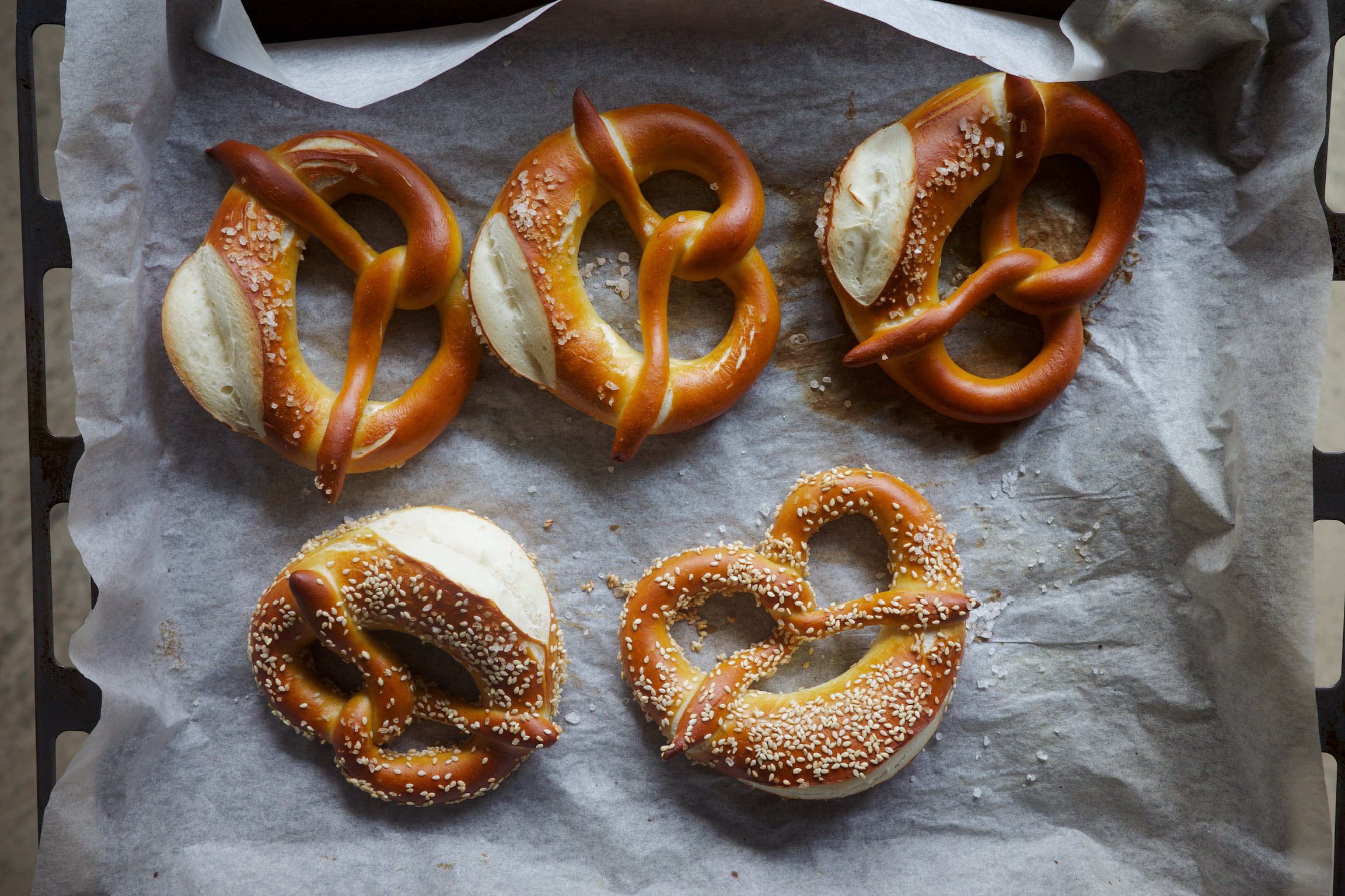 5 pretzels on a baking tray.