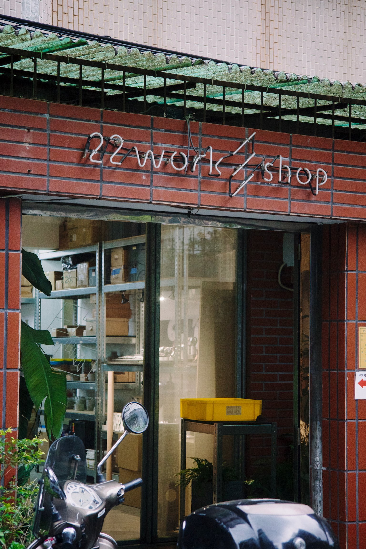 the entrance to 22 workshop, brick structure with neon sign and window doors.