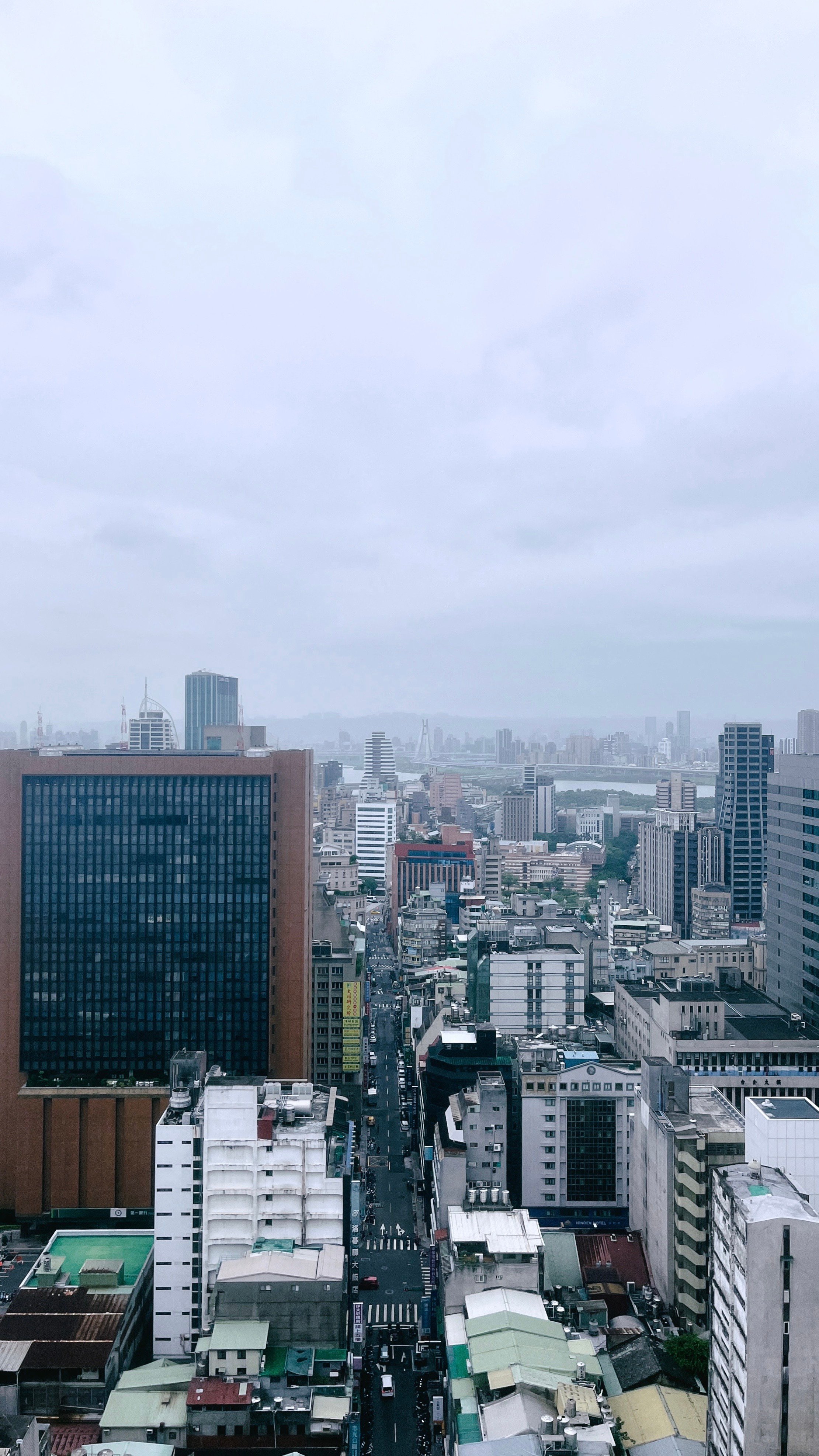 cityscape with short and tall buildings under a cloudy sky

