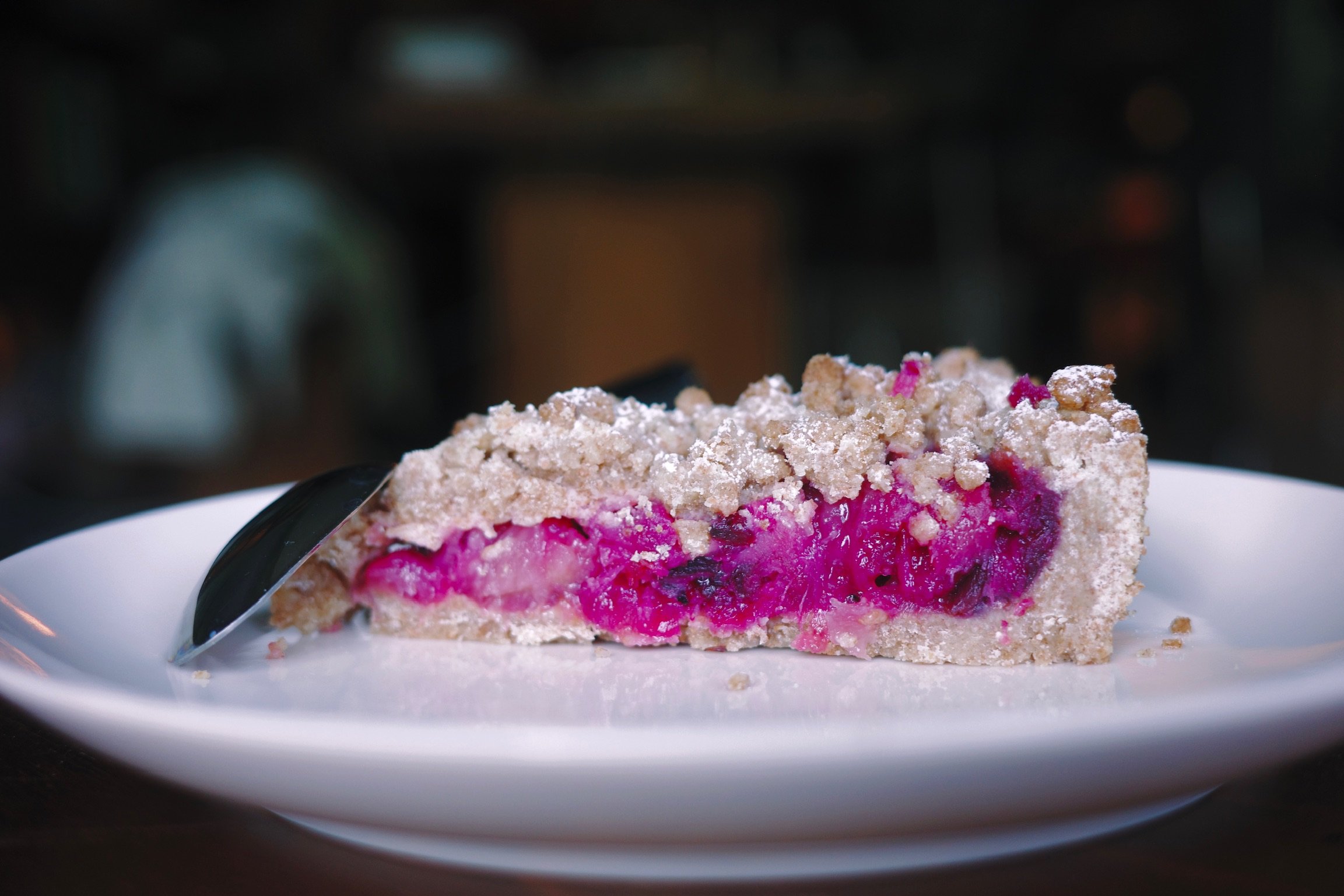 A crumble pie on a plate stuffed with pineapple and roselle.